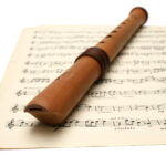 A recorder resting on a sheet of music