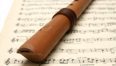 A recorder resting on a sheet of music