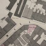 Alt text: An old map of Manchester that has been coloured in pale pink and blue. It shows the Sun Inn opposite the entrance to Chetham's Library on Long Millgate.