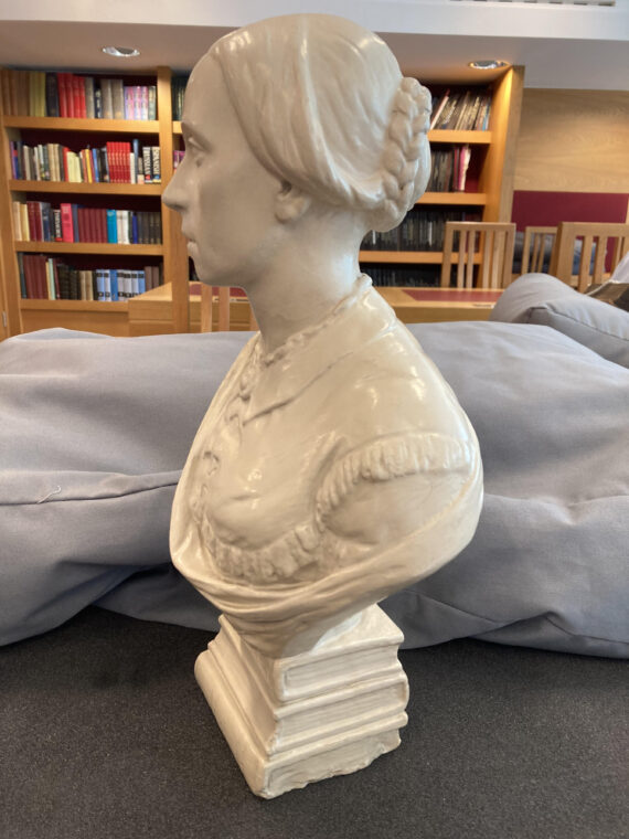 A bust of a young Isabella Varley, photographed side-on. The bust is white, and Isabella has her hair tied up in a bun.