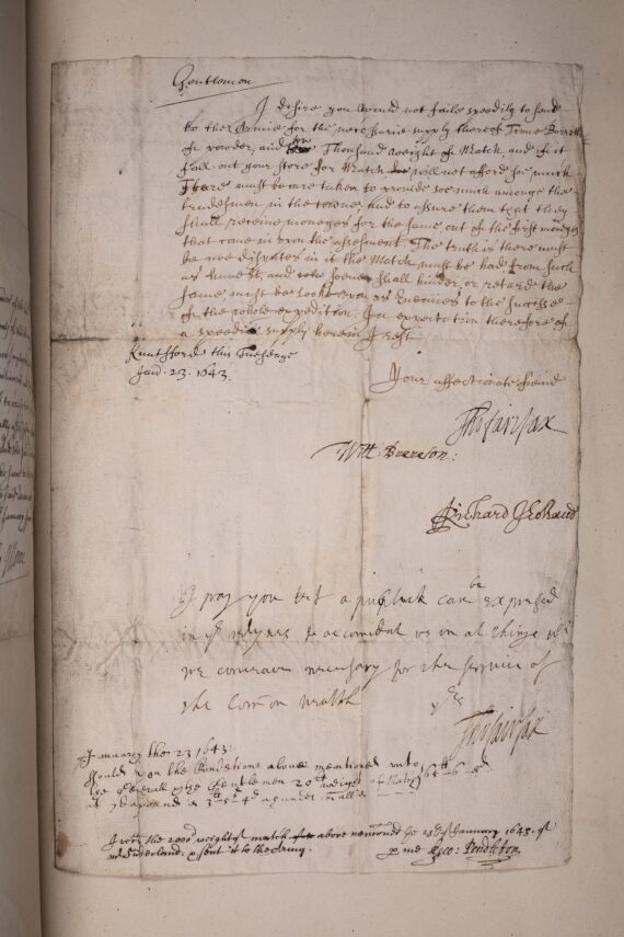 A handwritten letter in a cursive hand, beneath which are several signatures. The letter has been pasted down to the page of a book.