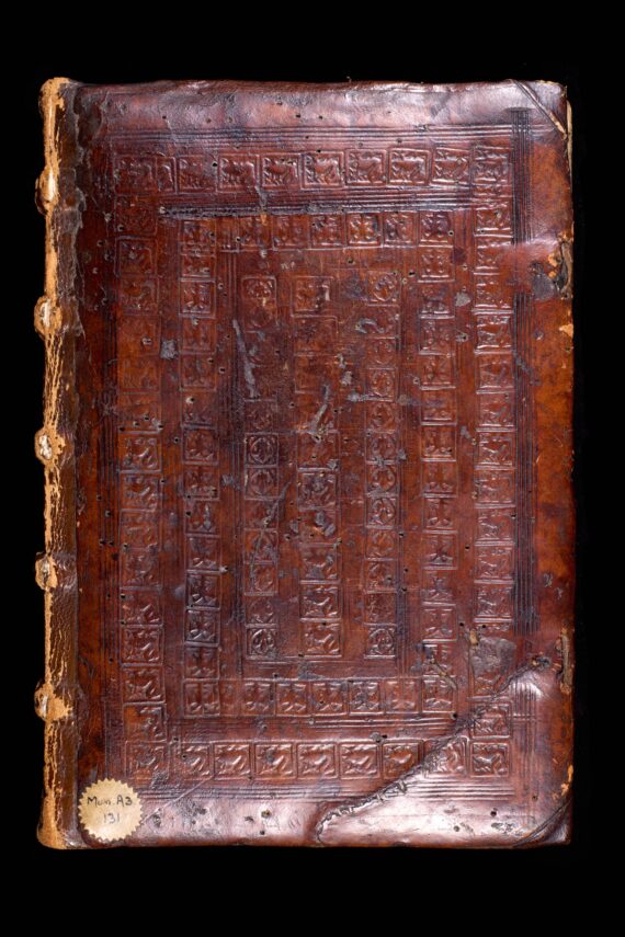 The cover of a book bound in deep brown leather, with an elaborate blind-stamped design. The design is formed of concentric rectangles, each made up of several smaller square stamps depicting swans, eagles and fleurs-de-lis.