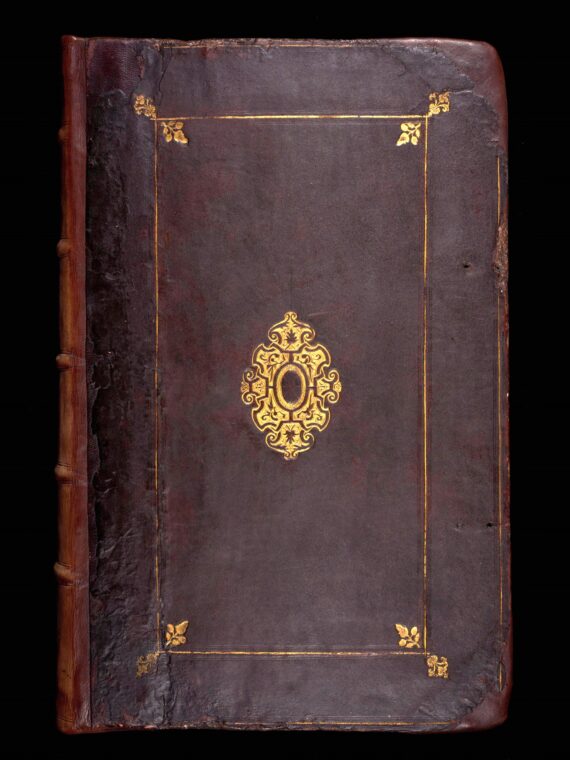 A book bound in dark brown leather. In the centre of the cover is a gilt-stamped entrelac design, and around the edges is a gilt rectangular fillet border with gilt-stamped acorns in the corners.