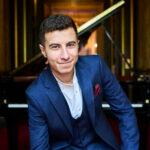 Artist Iyad Sughayer in front of a piano