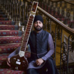 Jasdeep Singh Degun sits holding a sitar