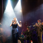 A female signer onstage with Down for the Count orchestra