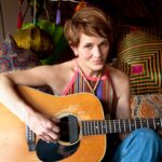 Singer Shawn Colvin, sitting with guitar