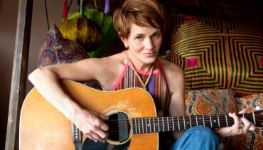 Singer Shawn Colvin, sitting with guitar