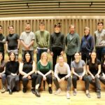 Kantos chamber choir sit on the stage of the Stoller hall