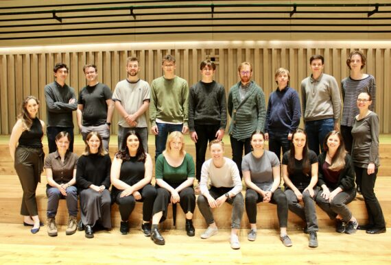 Kantos chamber choir sit on the stage of the Stoller hall