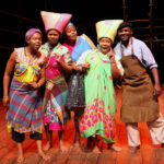 Members of theatre company Portobello Isango in brightly coloured costumes