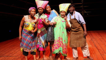 Members of theatre company Portobello Isango in brightly coloured costumes