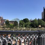 View of Cathedral Gardens and the Cathedral in Manchester against a blue sky