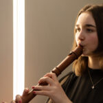 A girl playing a wooden recorder