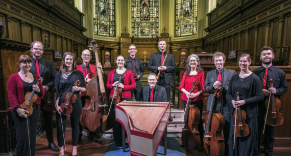 Manchester Baroque - a large group of musicians with instruments wearing red and black