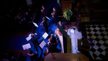 An overhead shot of manchester Baroque performing, lit by blue lights