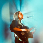 Josienne Clarke performing with guitar against blue background