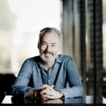 Singer Mark Padmore, sitting, wearing a blue shirt