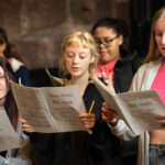 A group of singers holding music scores
