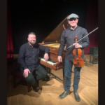 Tom McConville and Michael Biggins against a grand piano