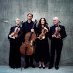 Members of the Engegard quartet against a grey background, holding instruments