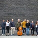 Musicians from Solomon's Knot standing in front of a brick wall