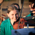 Child in green shirt with violin