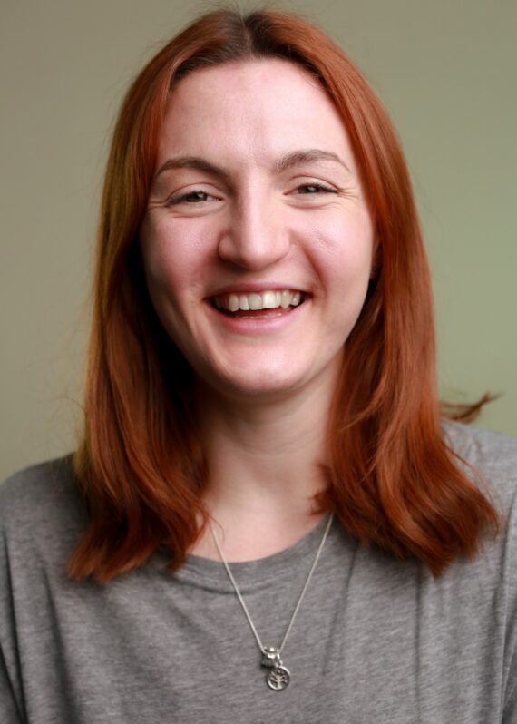 headshot of women with red hair and grey top