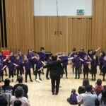 a group of children performing in front of an audience