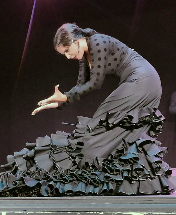 A women in a long black dress dancing