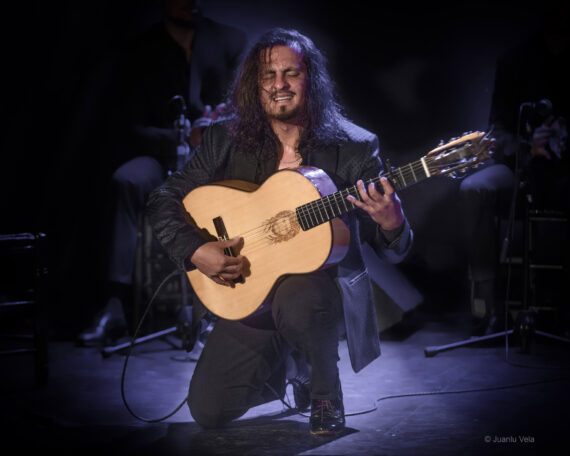 A man plays guitar on stage