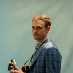 Musician Chris Thile holding mandolin (a guitar-like string instrument)
