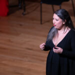 female singer on stage dressed in black