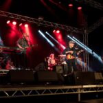 Members of the band Lindisfarne performing on stage