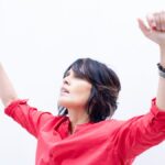 Singer Tanita Tikaram wearing a red shirt on a pale background