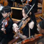 Three young Chetham's students playing violins