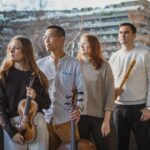 Four people (two men and two women) with instruments