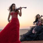 The Ayoub sisters - a violinist in a long red dress and a cellist in a dark blue dress