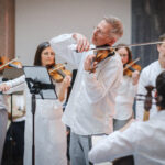 musicians from scottish ensemble dressed in white playing instruments